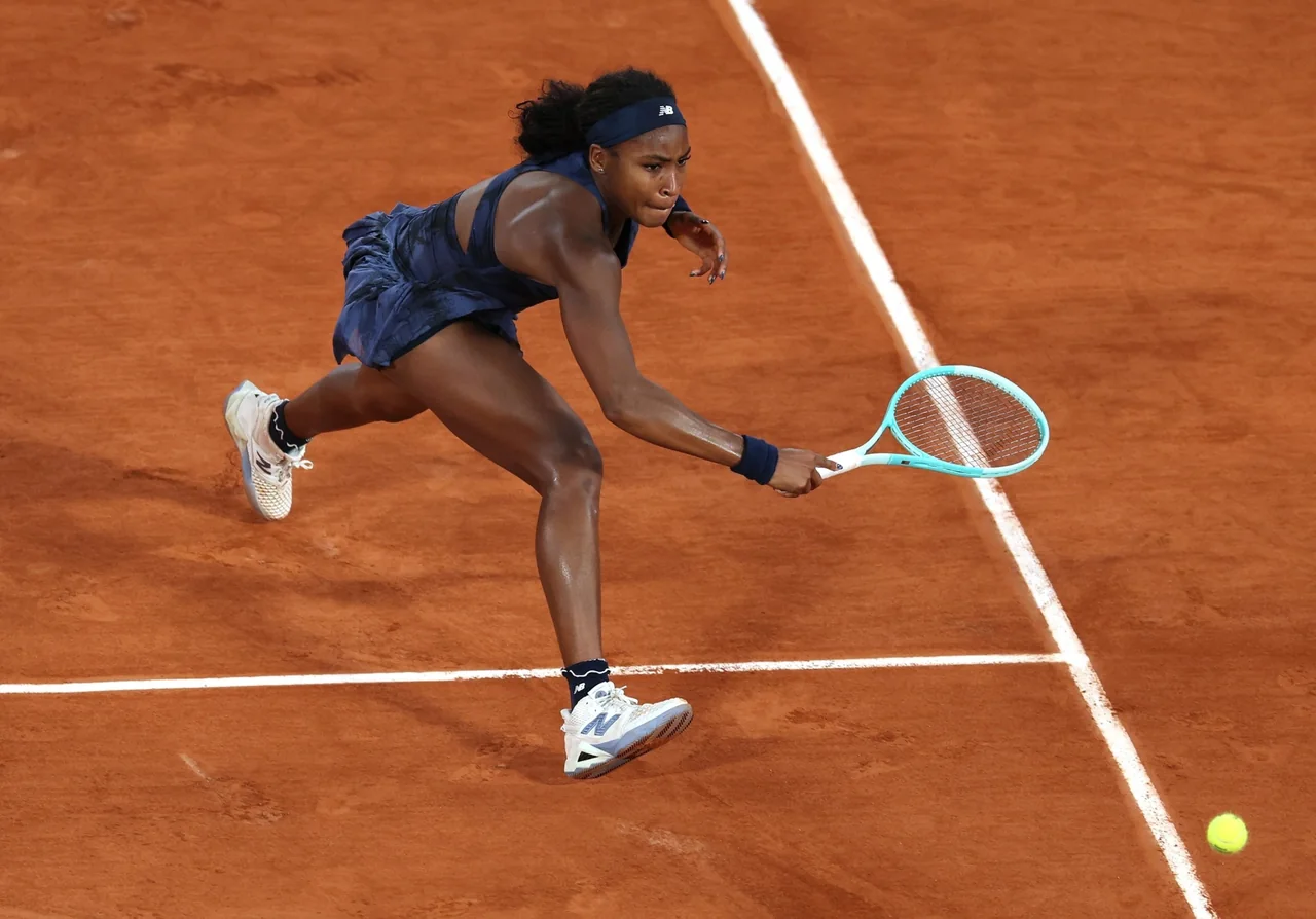 Coco Gauff reikt op de gravelbaan naar een bal tijdens een wedstrijd.