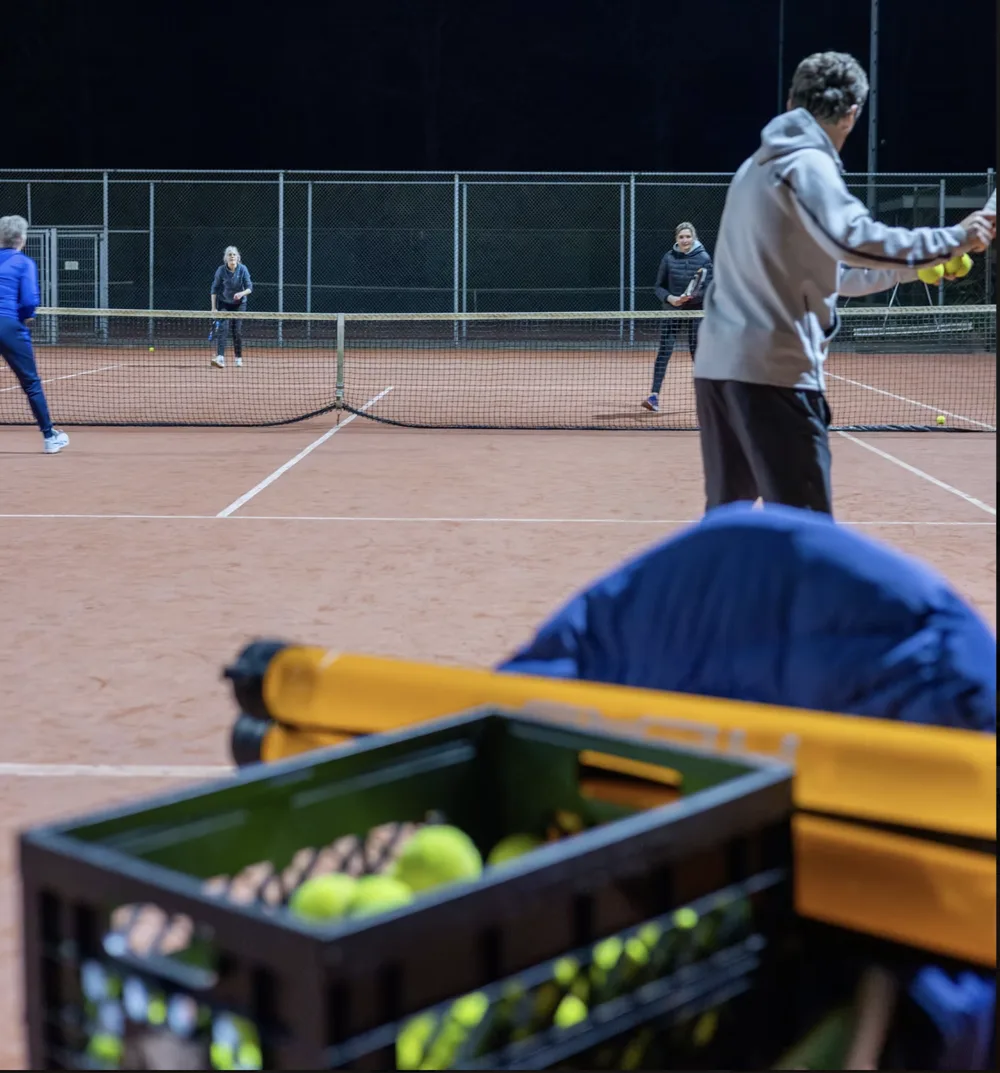 Spelers oefenen samen op de tennisbaan